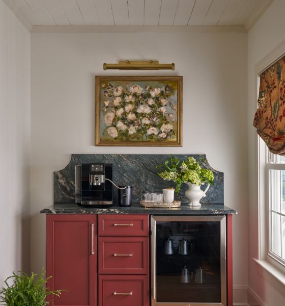 The coffee bar, with oxblood cabinetry and a floral painting