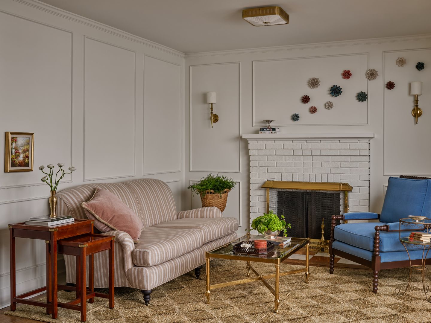 The sitting room: a striped sofa, a blue armchair and a white brick fireplace